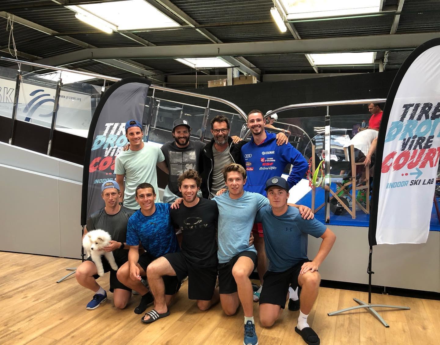 A smiling group beside a PROLESKI indoor ski simulator at TDVC Indoor Ski Lab