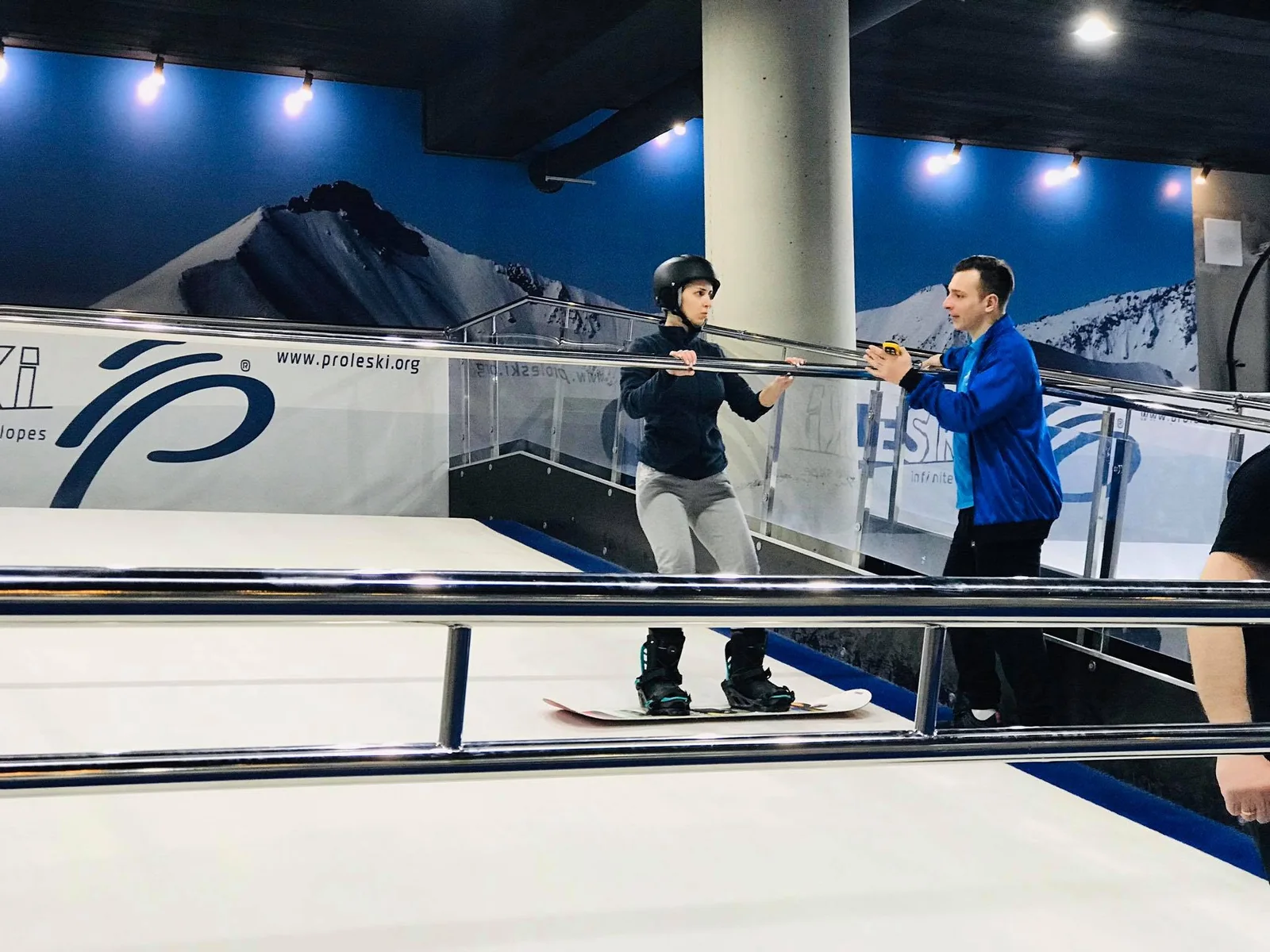Snowboard Coaching on a PROLESKI Ski Machine An instructor explaining technique to a snowboarder on a ski simulator at PROLESKI Georgia